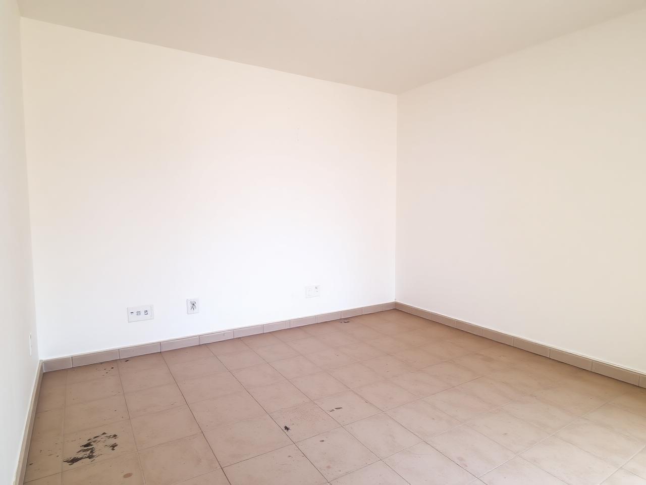 Empty apartment living room with bare walls and dull tiled floor